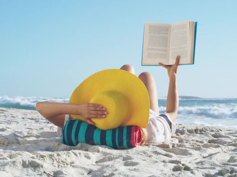 девушка читает книгу на пляже